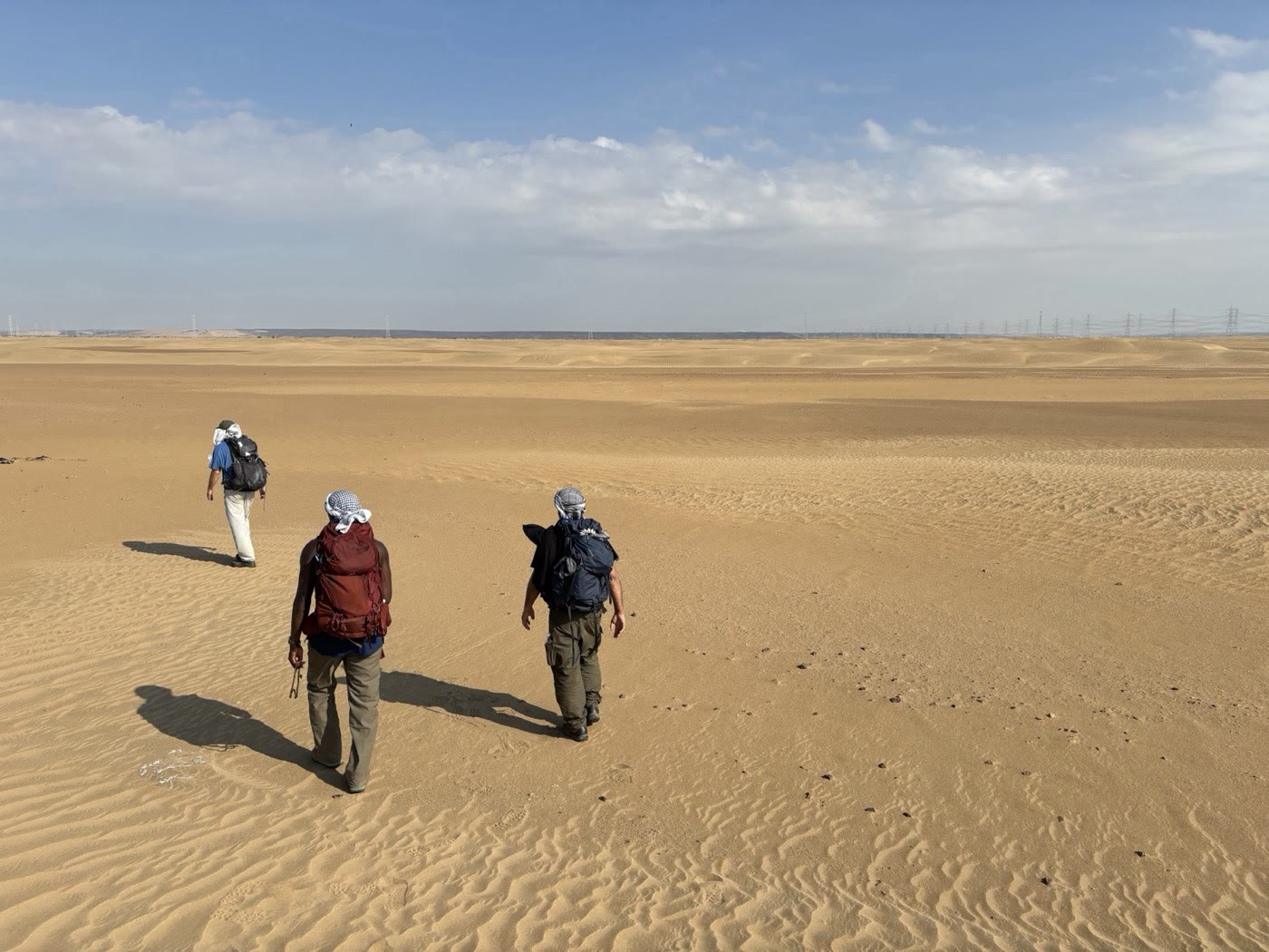 Walkers crossing the sand on the route